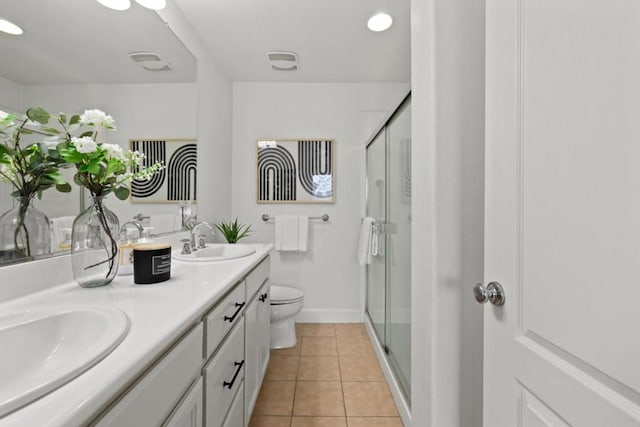 bathroom featuring vanity, toilet, a shower with shower door, and tile patterned flooring