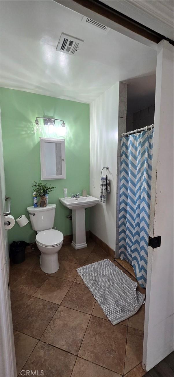 full bathroom with curtained shower, visible vents, toilet, baseboards, and tile patterned floors