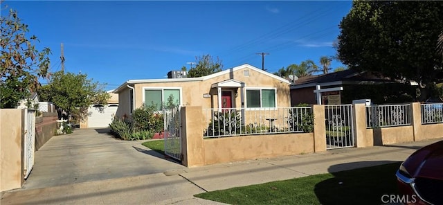 bungalow featuring a garage, a fenced front yard, and stucco siding