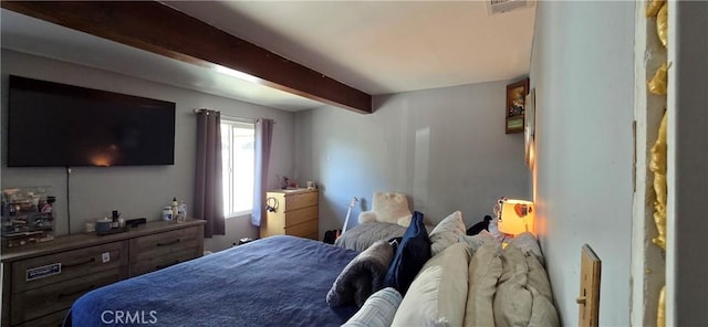 bedroom featuring beamed ceiling and visible vents