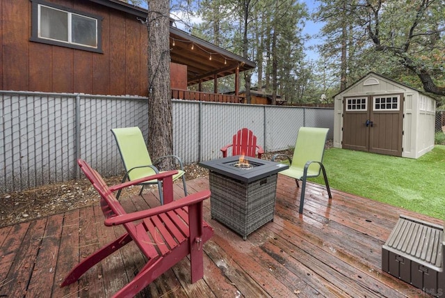 deck featuring a storage unit, a lawn, and a fire pit