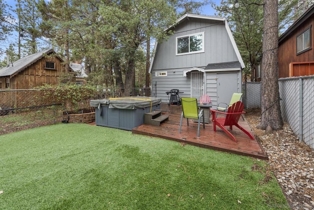 view of yard featuring a wooden deck, a hot tub, and an outdoor structure