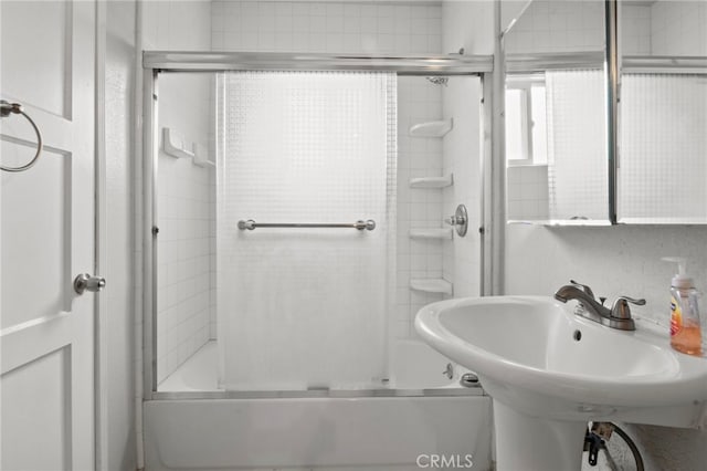 bathroom with bath / shower combo with glass door