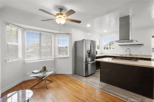 kitchen with stainless steel appliances, crown molding, island range hood, and light hardwood / wood-style flooring