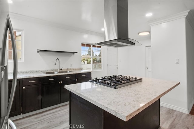 kitchen with a kitchen island, sink, island exhaust hood, ornamental molding, and gas cooktop