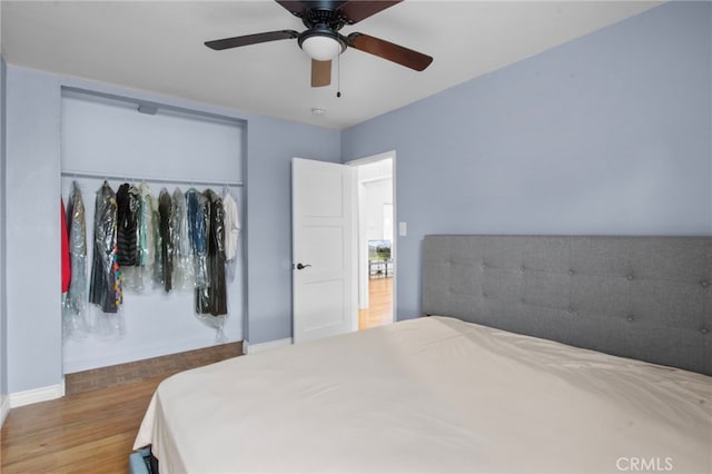 bedroom featuring ceiling fan, wood-type flooring, and a closet