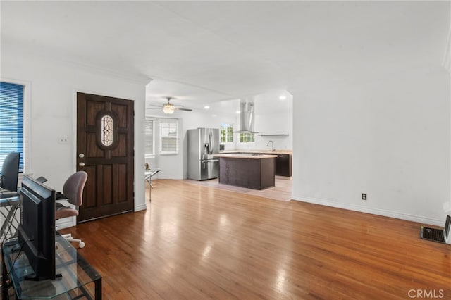 living room featuring ceiling fan, wood-type flooring, and sink