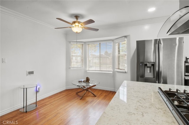 kitchen featuring light stone counters, ornamental molding, light hardwood / wood-style floors, and stainless steel fridge with ice dispenser