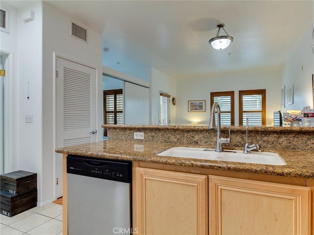 kitchen featuring dishwasher, sink, light brown cabinets, and a wealth of natural light