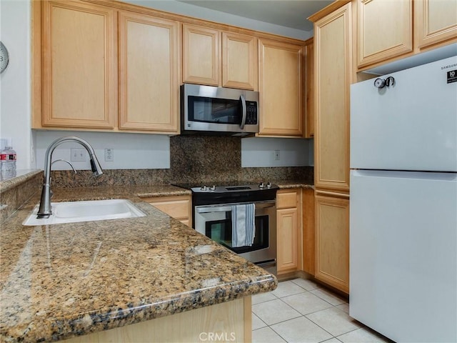 kitchen with light tile patterned flooring, appliances with stainless steel finishes, sink, and light brown cabinetry