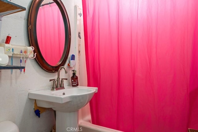 bathroom featuring toilet and shower / bath combo with shower curtain