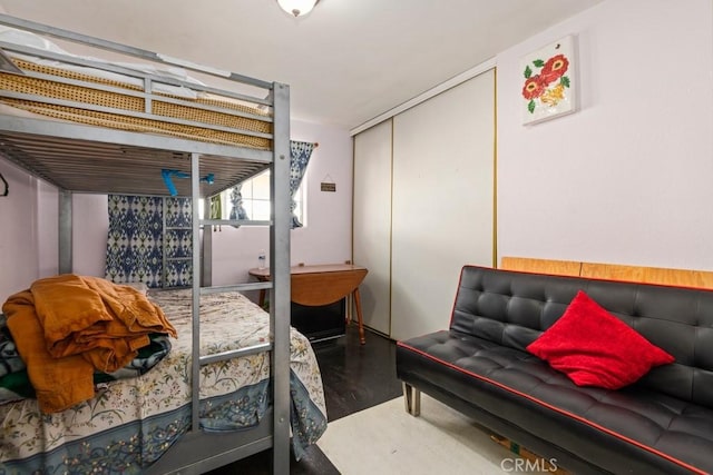 bedroom with concrete floors and a closet