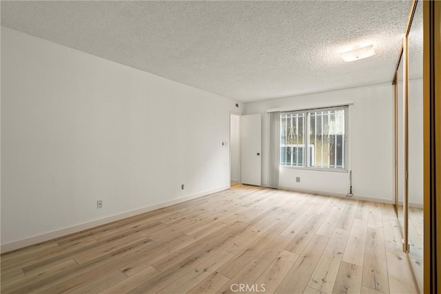 8740 Tuscany Ave Unit 109, Playa Del Rey, CA 90293 - unfurnished room featuring light wood-style flooring, a textured ceiling, and baseboards