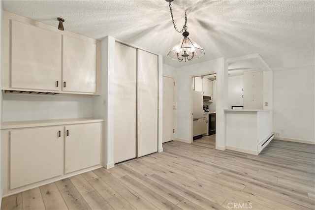 kitchen with hanging light fixtures, a baseboard heating unit, light hardwood / wood-style floors, white cabinets, and white fridge