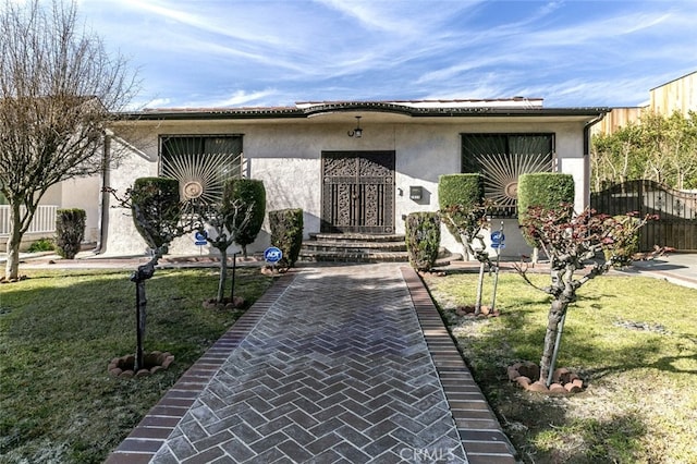 view of front of property featuring stucco siding and a front yard