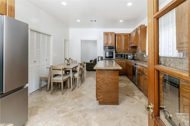 kitchen with tasteful backsplash, custom exhaust hood, stainless steel appliances, and a kitchen island