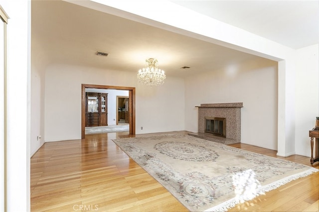 living room featuring a notable chandelier, a fireplace, and wood-type flooring