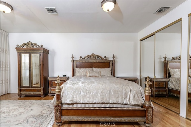 bedroom with wood-type flooring and a closet