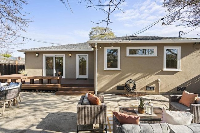 back of property with an outdoor living space, a patio, and a deck