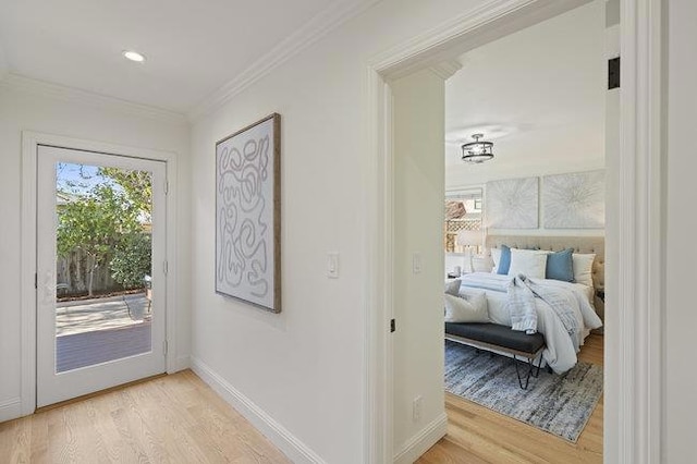 entryway featuring ornamental molding and light hardwood / wood-style flooring