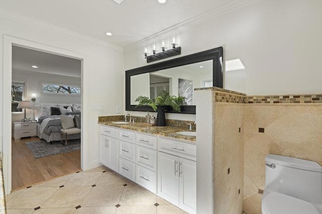 bathroom with tile patterned flooring, crown molding, tile walls, and vanity