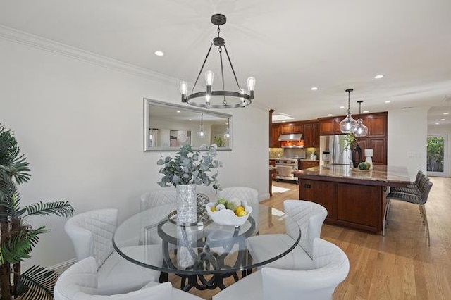 dining room featuring an inviting chandelier, crown molding, and light wood-type flooring