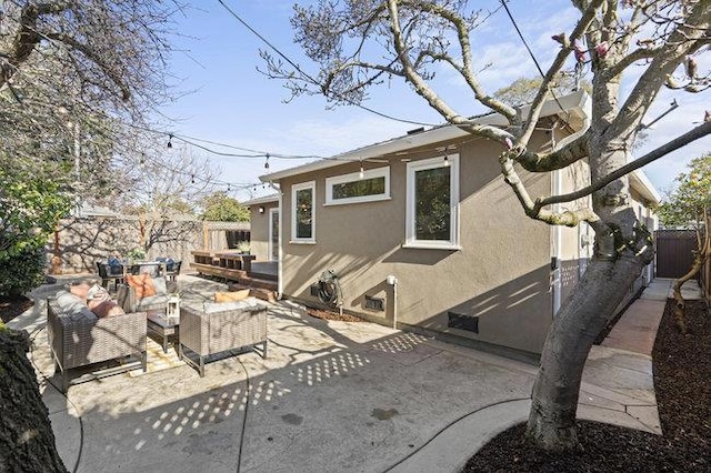 back of property with an outdoor living space and a patio