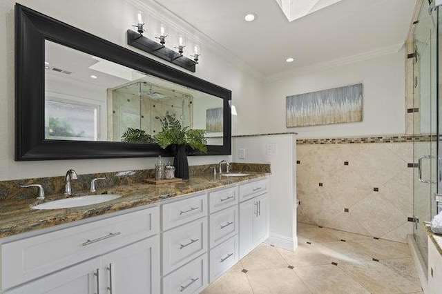 bathroom with a shower with shower door, tile walls, tile patterned flooring, ornamental molding, and vanity