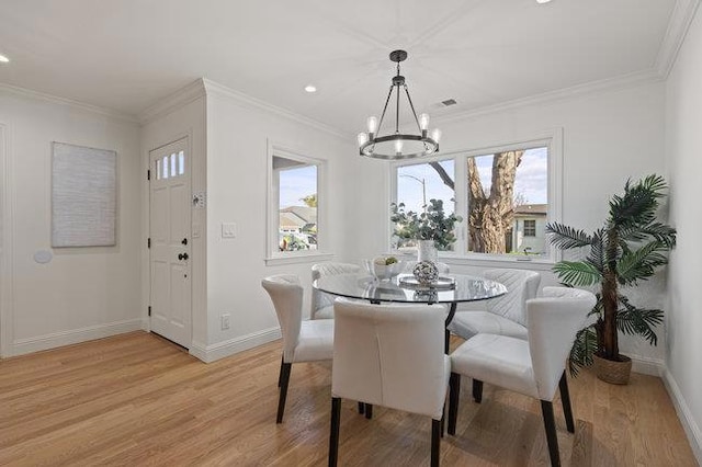 dining area featuring a notable chandelier, crown molding, and light wood-type flooring