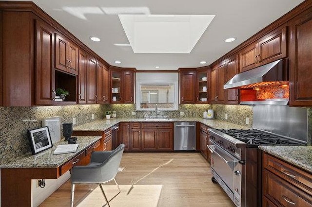 kitchen with light stone counters, sink, tasteful backsplash, and stainless steel appliances