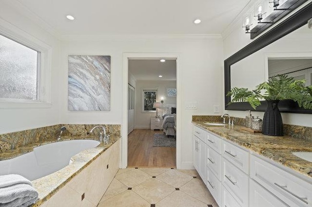 bathroom with crown molding, tile patterned floors, vanity, and tiled tub