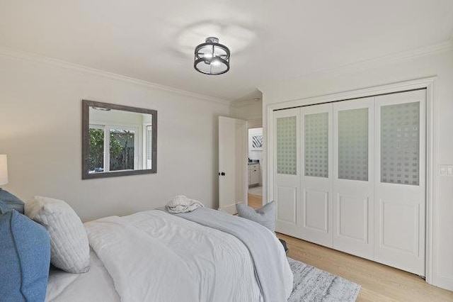 bedroom featuring crown molding, a closet, and light hardwood / wood-style flooring