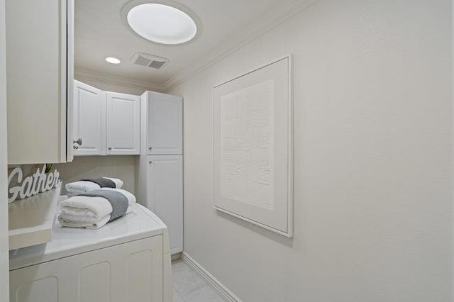 laundry room featuring cabinets, ornamental molding, and washer / dryer