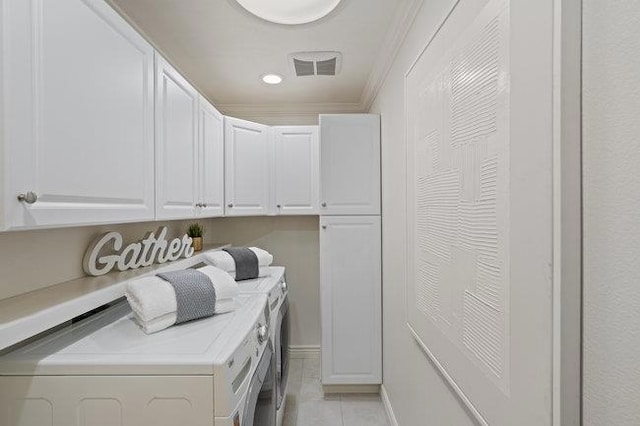 clothes washing area featuring cabinets, ornamental molding, separate washer and dryer, and light tile patterned floors