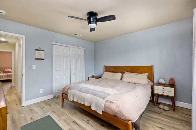 bedroom with ceiling fan, a closet, and light hardwood / wood-style flooring