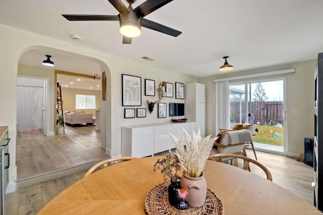 dining space with ceiling fan and light hardwood / wood-style flooring