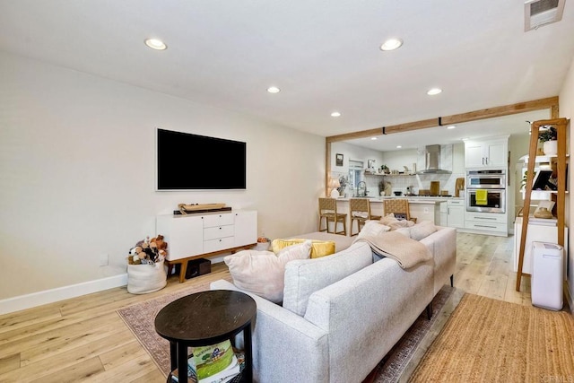 living room featuring sink and light wood-type flooring