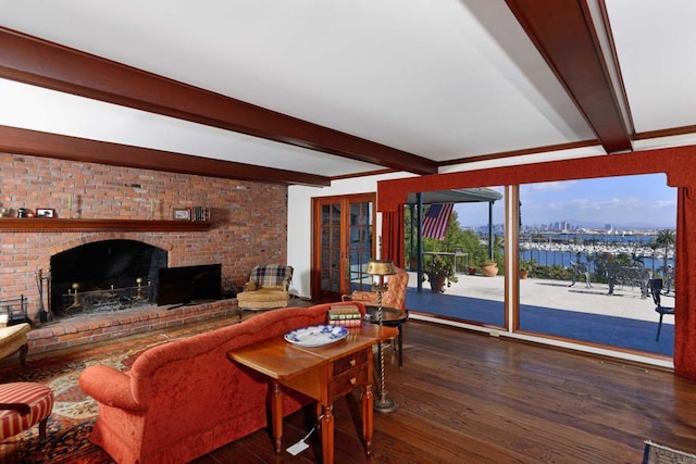 living room featuring dark hardwood / wood-style flooring, a fireplace, beamed ceiling, and a water view