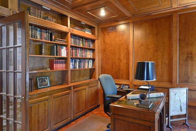 office area featuring coffered ceiling, built in shelves, ornamental molding, and wood walls