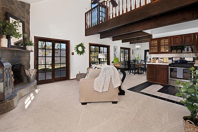 carpeted living room featuring beam ceiling, a towering ceiling, french doors, and an inviting chandelier