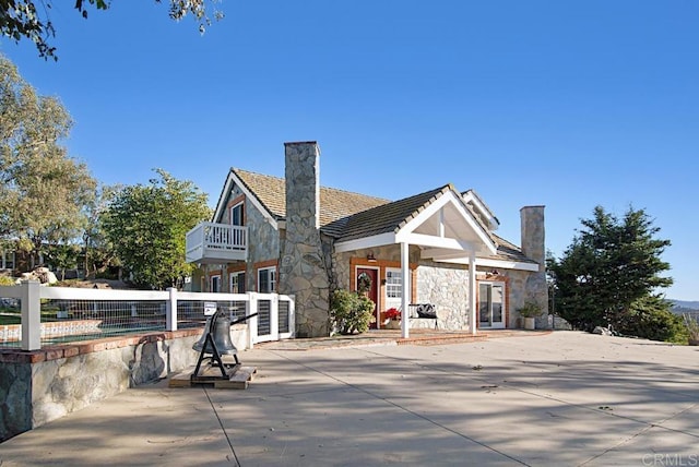 rear view of property with a balcony and a patio area