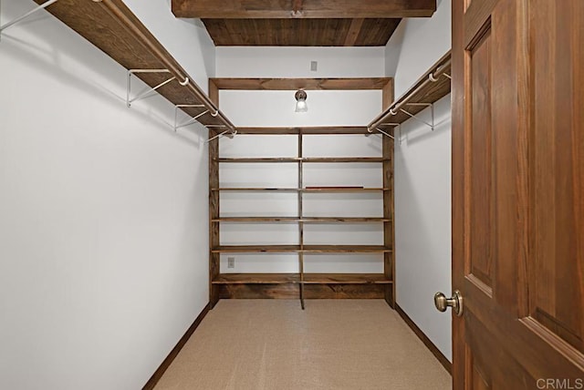 walk in closet with beam ceiling