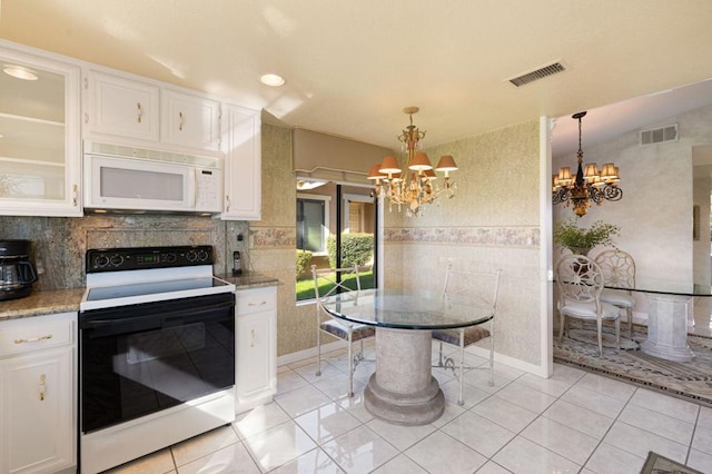 kitchen with white cabinets, decorative light fixtures, a chandelier, and electric range