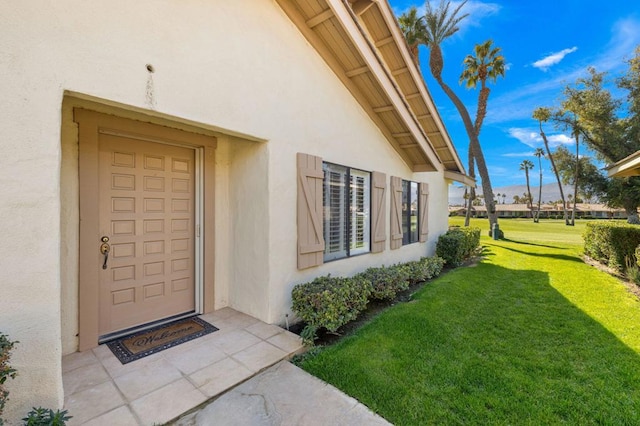 entrance to property featuring a lawn