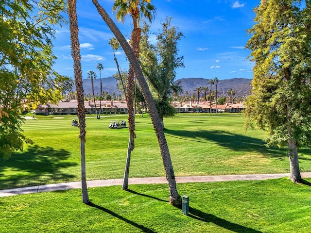 surrounding community featuring a mountain view and a lawn