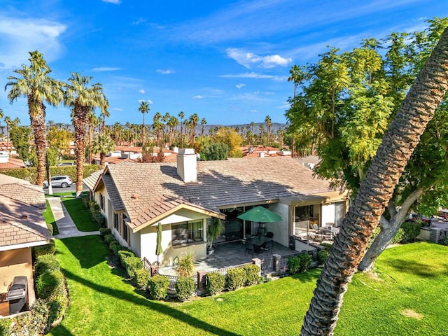 back of property with a patio and a yard