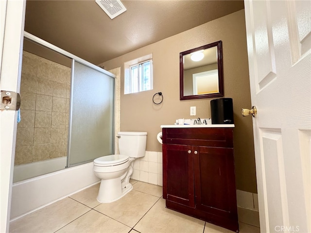 full bathroom with enclosed tub / shower combo, tile patterned floors, toilet, and vanity