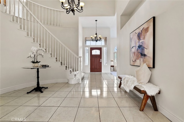 tiled entrance foyer featuring a chandelier and a high ceiling