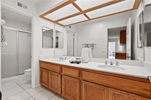 bathroom featuring vanity, tile patterned floors, toilet, and walk in shower