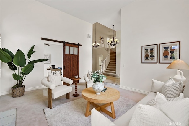 carpeted living room featuring a high ceiling, a barn door, and a notable chandelier